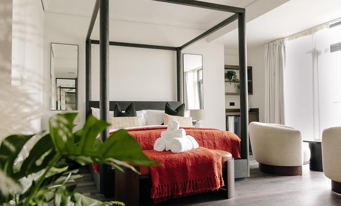 Introducing our spacious suite with a four-poster super king-sized bed, beautiful standalone bath, fireplace, and adjoining lounge.